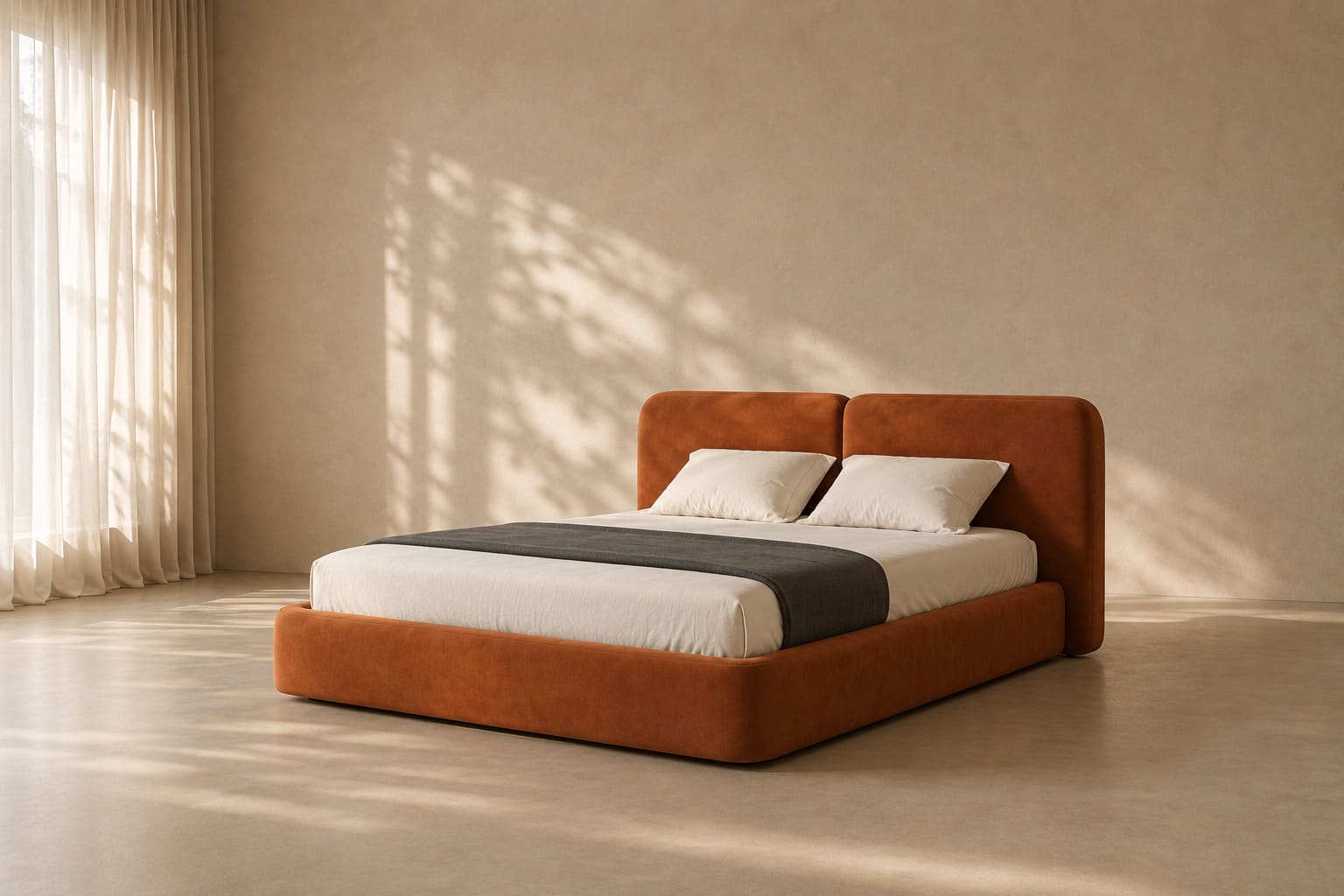 Upholstered double bed in rust velvet with a two-panel rounded headboard and a deep plinth base, made up with white bedding and a dark grey throw.
